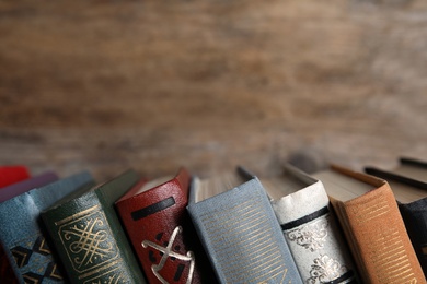 Photo of Stack of hardcover books on wooden background, closeup. Space for text