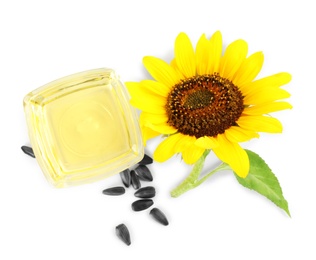 Photo of Sunflower, oil in glass bowl and seeds on white background, top view