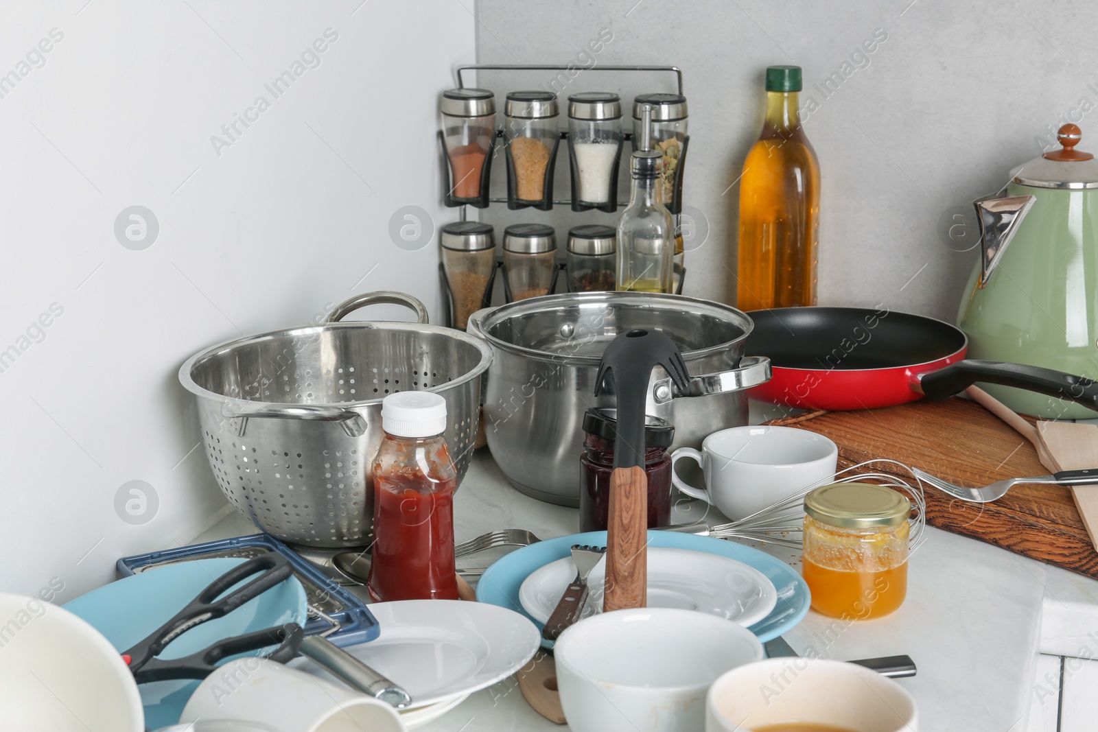 Photo of Many dirty utensils, cookware and dishware on countertop in messy kitchen