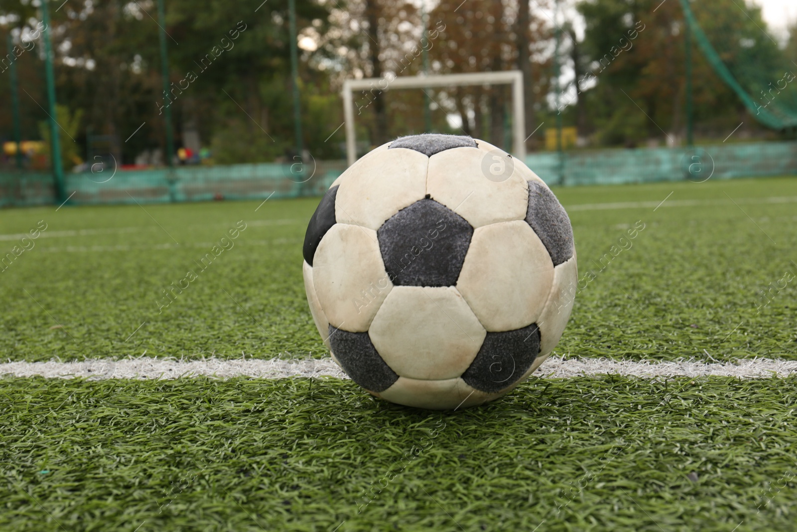 Photo of Dirty soccer ball on green football field