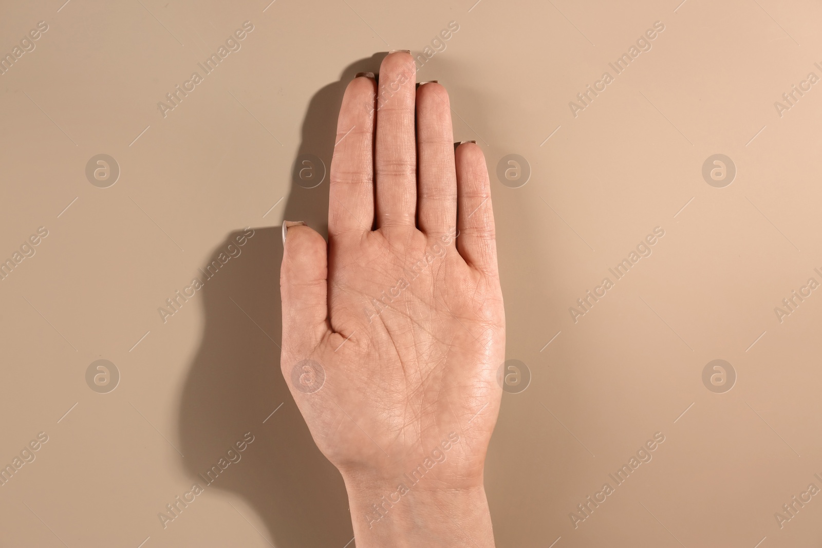 Photo of Woman showing palm on color background, top view. Chiromancy and foretelling