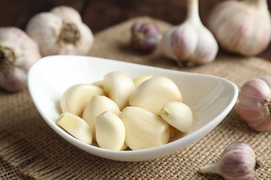 Fresh garlic cloves and bulbs on table, closeup