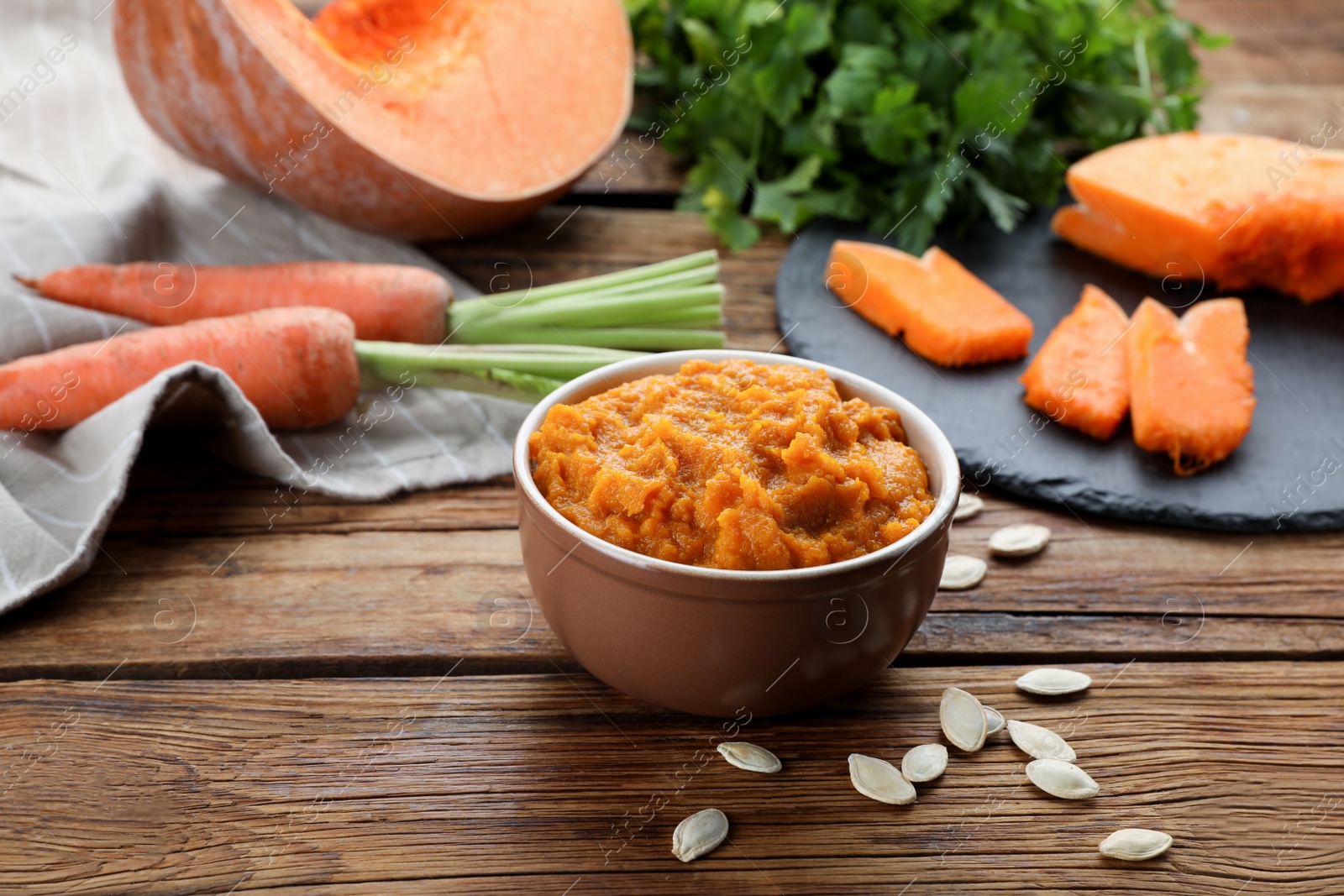 Photo of Bowl with tasty puree and ingredients on wooden table