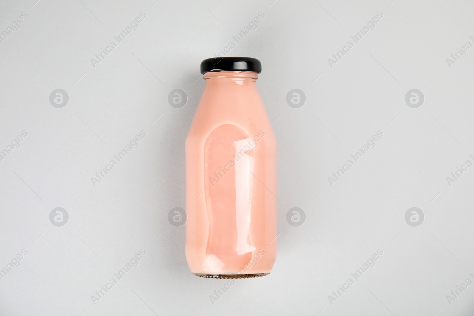 Photo of One bottle with tasty drink on color background, top view