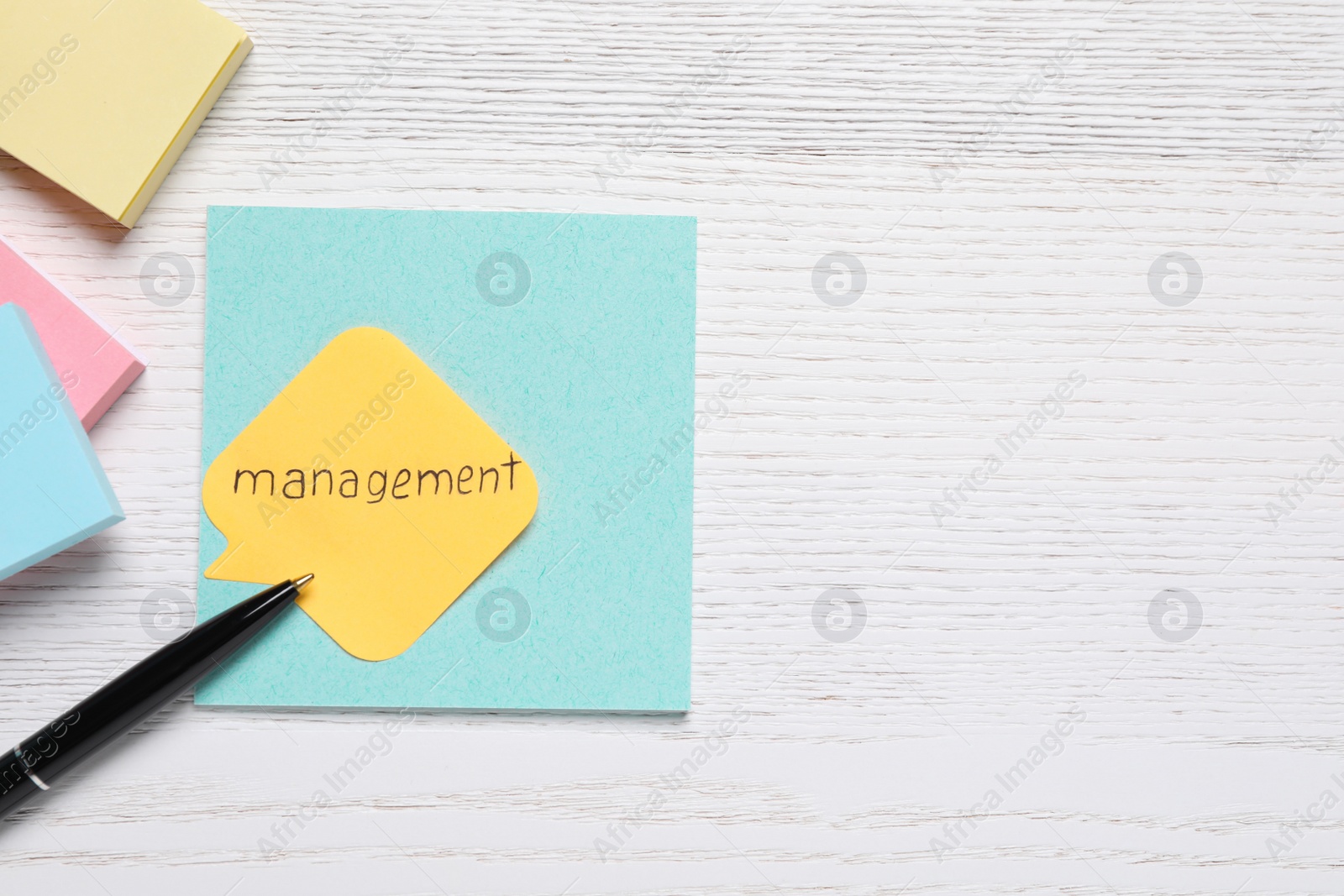 Photo of Paper note with word Management and pen on white wooden table, flat lay. Space for text