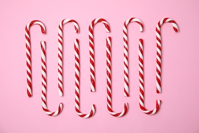 Flat lay composition with tasty candy canes on color background