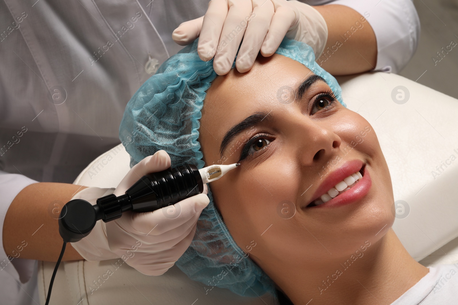 Photo of Young woman undergoing procedure of permanent eyeliner makeup, closeup