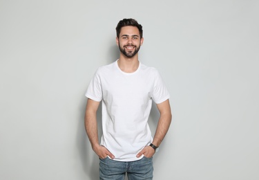 Photo of Young man in t-shirt on light background. Mock up for design