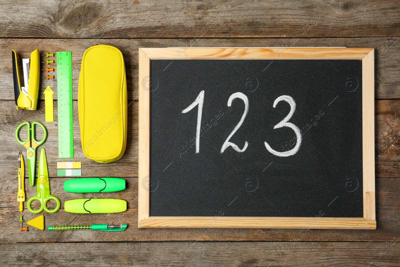 Photo of Flat lay composition with different school stationery and small chalkboard on wooden background