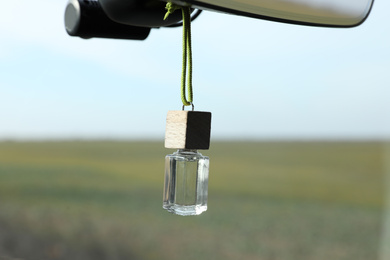 Photo of Air freshener hanging on rear view mirror in car