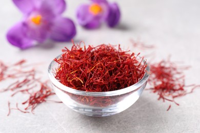 Dried saffron and crocus flowers on grey table, closeup