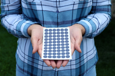 Photo of Woman holding solar panel outdoors, closeup view