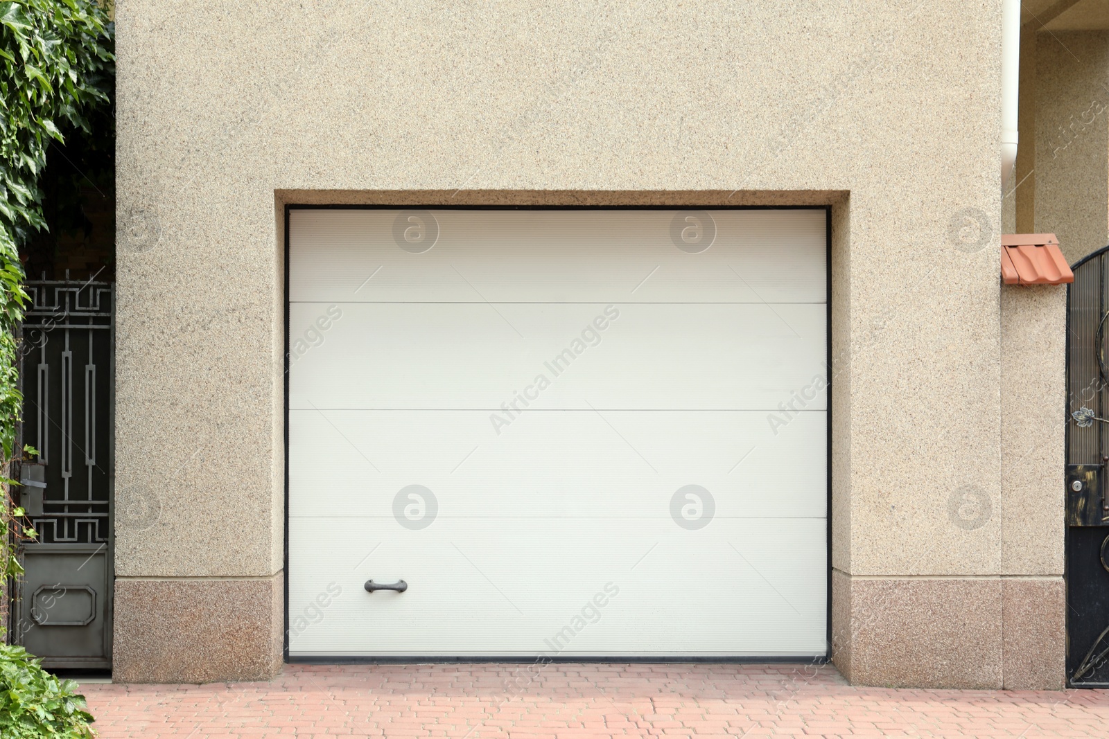 Photo of Building with white sectional garage door near entrance