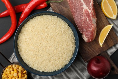 Photo of Flat lay composition with different ingredients on black background. Risotto recipe