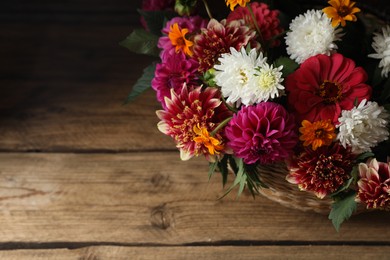 Photo of Beautiful wild flowers and leaves on wooden table, above view. Space for text