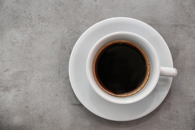 Photo of Cup of fresh aromatic coffee on grey background, top view