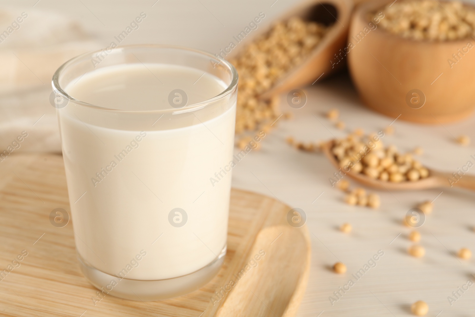 Photo of Fresh soy milk and beans on table, closeup. Space for text