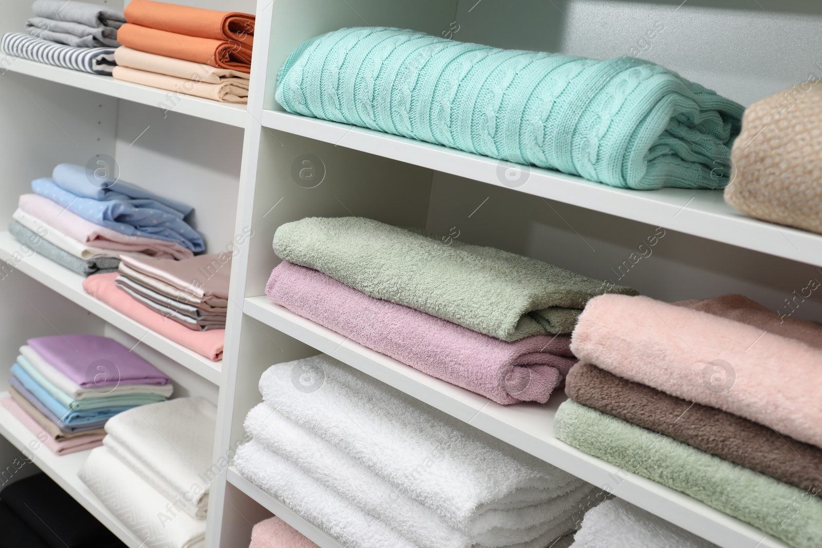 Photo of Different color linens on shelves in shop