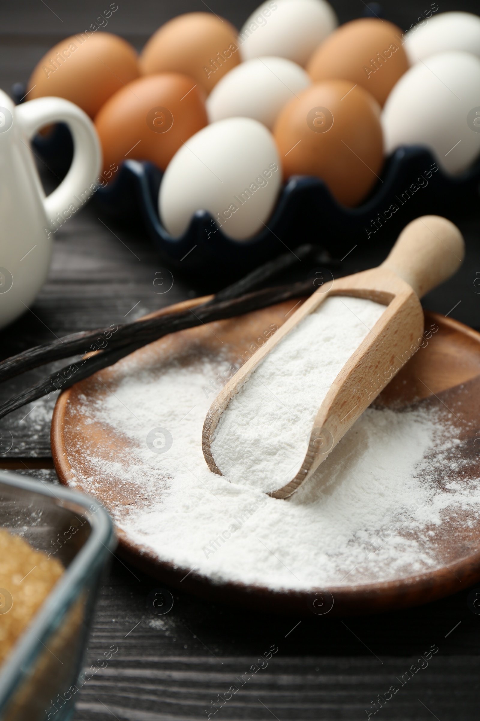 Photo of Baking powder and eggs on black wooden table, closeup