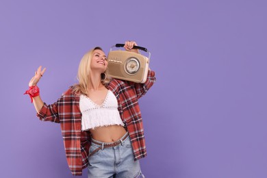 Happy hippie woman with retro radio receiver on purple background. Space for text