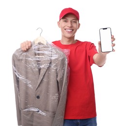 Dry-cleaning delivery. Happy courier holding jacket in plastic bag and smartphone on white background