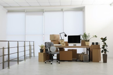 Cardboard boxes, computer and furniture in new office. Moving day