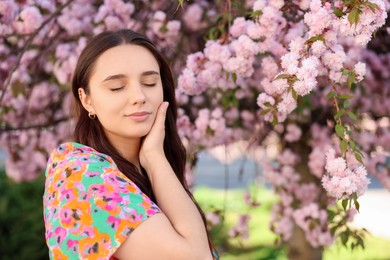 Photo of Beautiful woman near blossoming tree on spring day