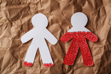 Photo of Human paper figures on brown background, flat lay. Relationship problems concept