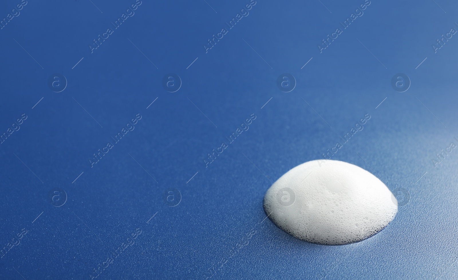 Photo of Drop of soap foam on color background. Space for text