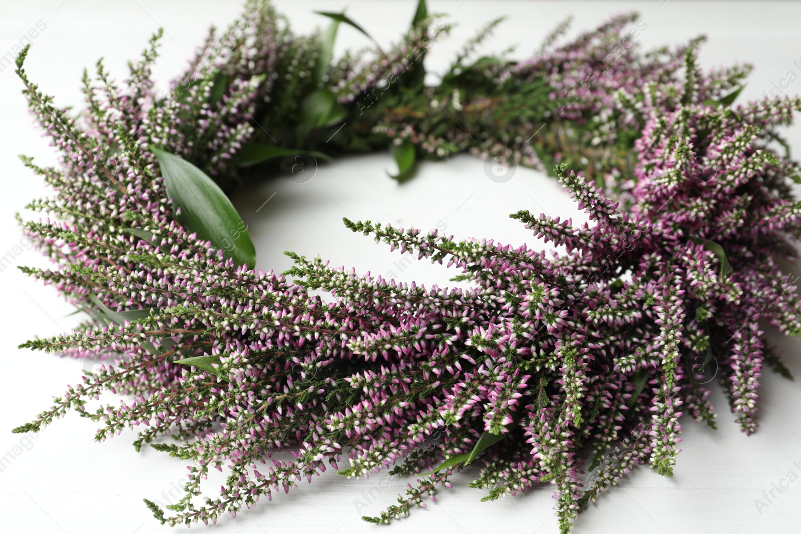 Photo of Beautiful autumnal wreath with heather flowers on white background, closeup