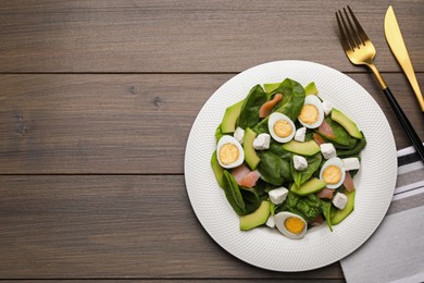 Photo of Delicious salad with boiled eggs, feta cheese and salmon served on wooden table, flat lay. Space for text