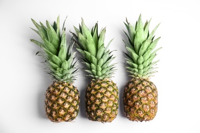 Fresh ripe pineapples on white background, flat lay