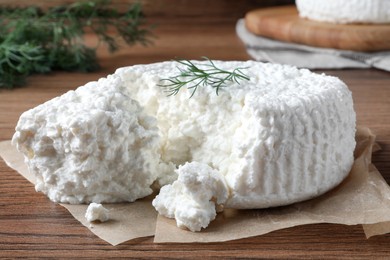 Delicious cottage cheese with dill on wooden table, closeup