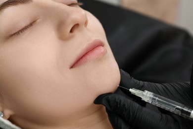 Photo of Cosmetologist giving facial injection to patient, closeup. Cosmetic surgery