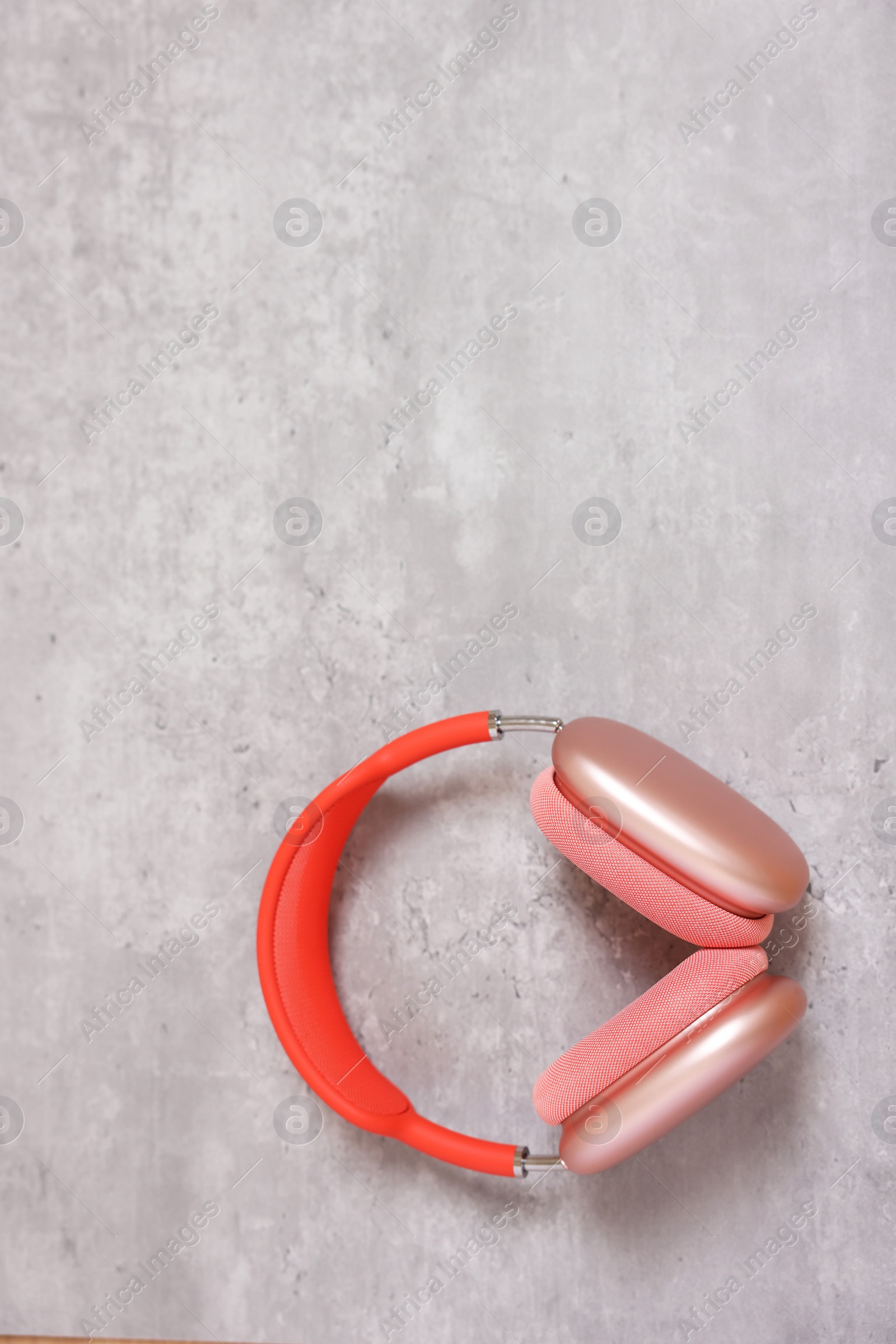 Photo of Stylish pink headphones on light grey table, top view. Space for text