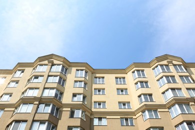 Exterior of multi storey apartment building against blue sky, low angle view