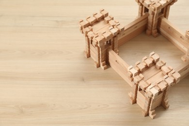 Photo of Wooden fortress on table, space for text. Children's toy