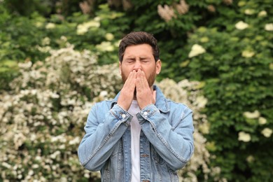 Man suffering from seasonal pollen allergy on spring day