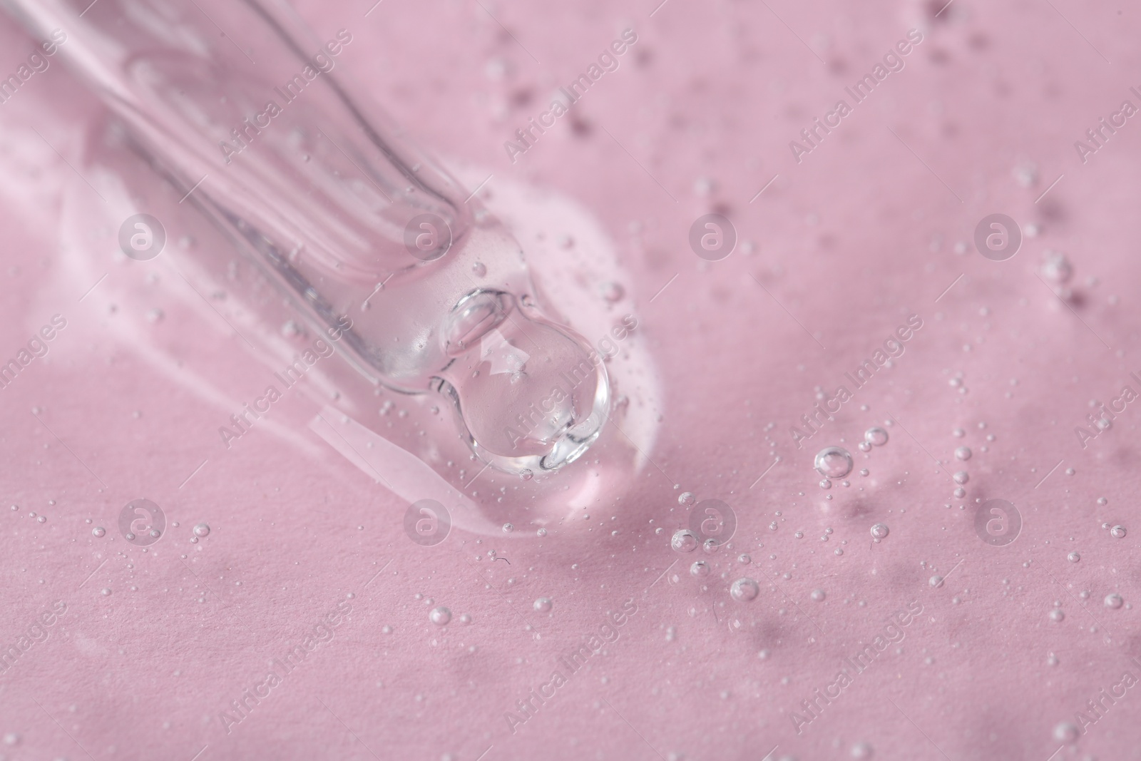 Photo of Pipette with cosmetic serum on pink background, closeup. Space for text