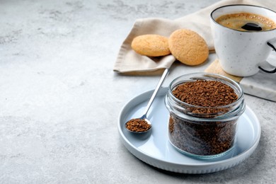 Photo of Glass jar of instant coffee, cup with drink and cookies on light table. Space for text