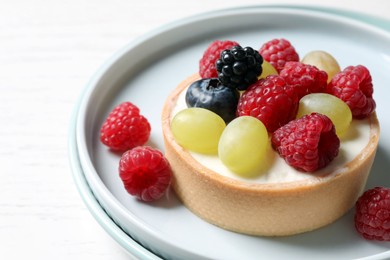 Photo of Delicious tartlet with berries on white table, closeup