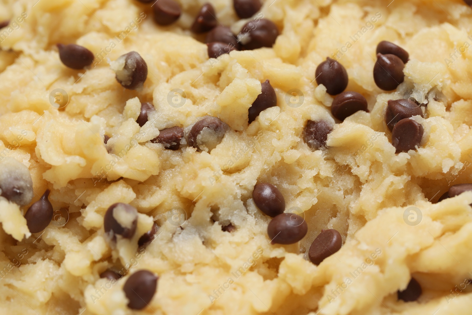 Photo of Raw dough for chocolate chip cookies as background, closeup