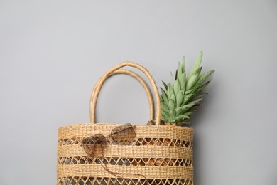 Photo of Stylish straw bag and sunglasses on grey background, flat lay. Summer accessories