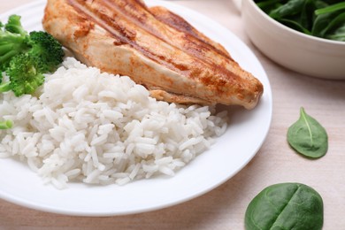 Photo of Grilled chicken breast and rice served with vegetables on wooden table, closeup