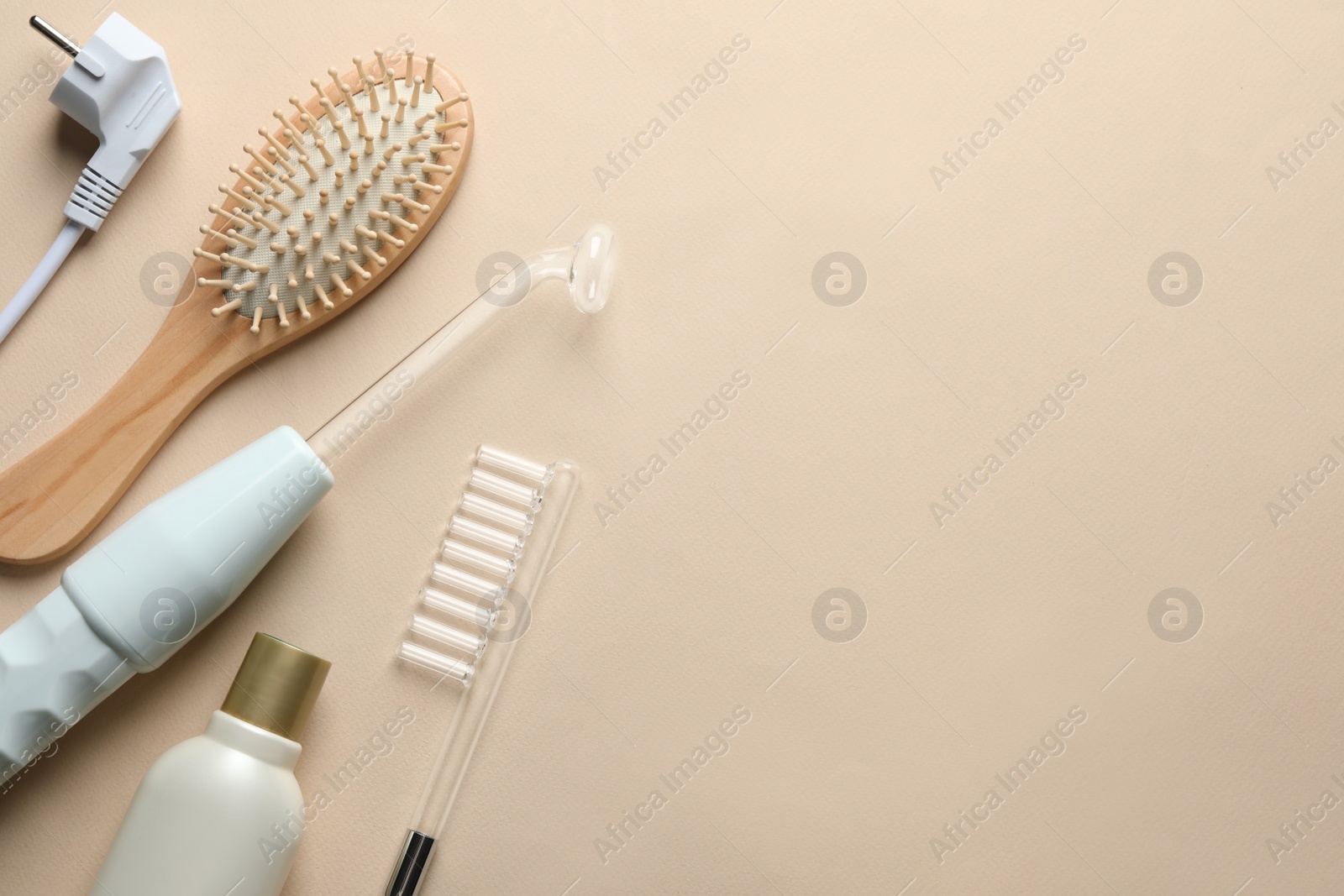 Photo of Flat lay composition with darsonval and different nozzles on beige background, space for text