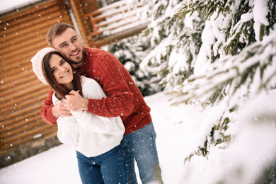 Lovely couple spending time together on snowy day. Winter vacation