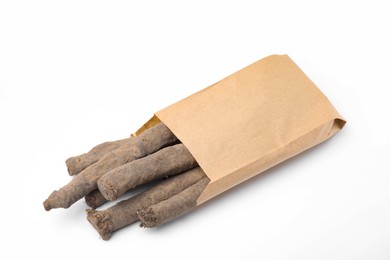Photo of Paper bag with raw salsify roots on white background