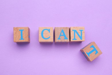Motivation concept. Changing phrase from I Can't into I Can by removing wooden cube with letter T on violet background, flat lay