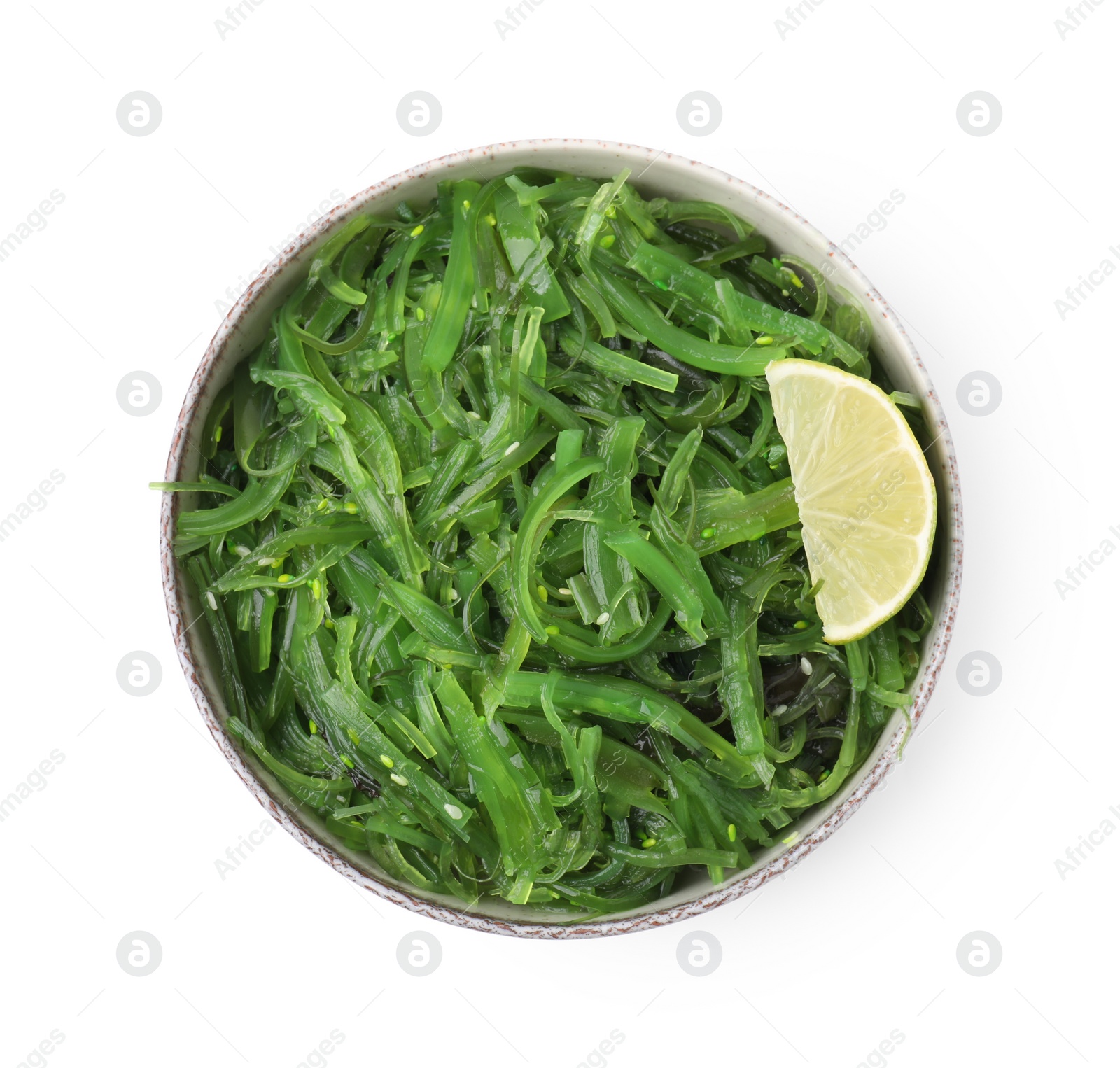 Photo of Tasty seaweed salad in bowl isolated on white, top view