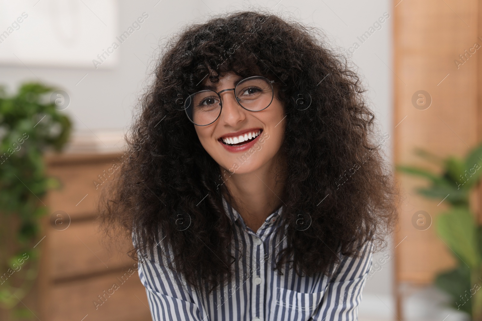 Photo of Portrait of beautiful woman in glasses indoors. Attractive lady smiling and looking into camera